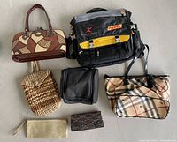 Photo showing various bags including handbags, computer bag, tote bag, vanity bag, and clutch purses arranged on floor