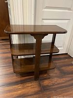 Side angle view of the wooden 3-shelf side table showing all three shelves and central support.
