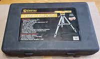 Closed black molded plastic carrying case displaying Craftex Laser Level Kit label with contents and specifications.