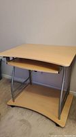 Side view of lightweight student desk showing metal frame and melamine surfaces including desktop and lower shelf.