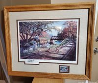 Overall view of framed print titled "Nary a Care" by Ken Zylla showing solid oak frame and included etching and commemorative stamp below the main artwork.