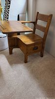 Side view of the vintage solid wood student desk showing attached chair and drawer under the seat.