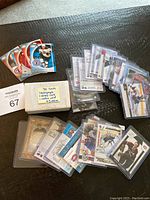 Photo of 50 hockey cards boxed set with white paper wrapping and handwritten label, plus loose and sleeved hockey cards spread on flat surface