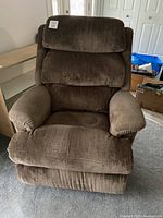 Front view of brown fabric reclining rocking chair, showing cushioned padded sections on backrest, seat and armrests.
