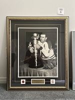 Framed black and white photo of Maurice Richard holding the Stanley Cup.