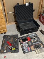 Open Pelican case with both foam trays removed and laid out with tools