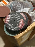Close-up of stacked sanding discs with specifications visible on one label
