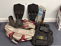 Full lot with two pairs of fins, beige red bag, snorkel in packaging, buoyancy compensator with mask