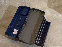 Blue and gray Mastercraft Maximum toolbox with upper lid compartments open showing interior storage tray and clear plastic lid cover as well as two metal latches on the front.