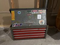 Front view of closed Craftsman toolbox showing 6 red drawers and top chest compartment with vintage stickers
