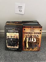 Front view of 13 Western DVD cases showing titles and cover art with Tombstone and Young Guns prominent.