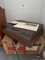 Turntable setup on original box with dust cover closed and paperwork on top