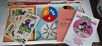 Sesame Street alphabet game cards, colorful spinners, and instruction booklets arranged in box.