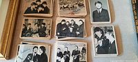 Multiple stacks of vintage black and white Beatles trading cards laid out on a surface with visible printed signatures of band members. Cards depict group and individual photos.