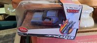 Photo of the small toy vehicle in its original sealed packaging showing the car inside and Disney Pixar Cars branding.
