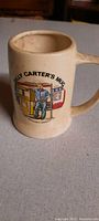 Stoneware mug showing full illustration of Billy Carter at his gas station, side view