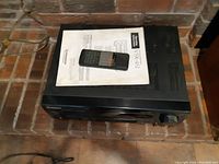 Top view of Pioneer VSX-452 stereo receiver with remote control and instruction manual on top.