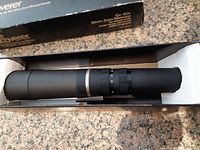Zoom telescope in original box with foam inserts showing telescope body and adjustment rings.