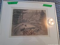 Photo of the framed monochromatic print showing the entire artwork within white mat and frame, highlighting the forest sketch with tree stumps and a winding path.