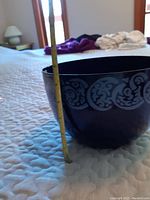 Side profile of dark blue enamel bowl with decorative pattern, measuring approximately 5.5 inches tall with tape measure included