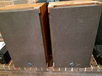 Pair of vintage Sony speakers shown side by side with cloth grills and wooden cabinets.