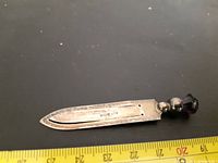 Close-up image of the sterling silver bookmark, showing length with ruler and hallmarks on the blade.
