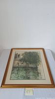Framed painting laid flat on white surface