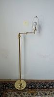Full view of the adjustable gold finish bridge floor lamp showing the height and bulb holder.
