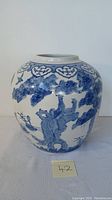 Front view of large Chinese ginger jar showing hand-painted blue wetlands and birds design on white porcelain.