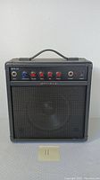 Front view of the black MPS-45 Optimus guitar amplifier showing control knobs, input, and power switch.