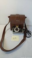 Full view of Yashica EZ-MATIC camera with attached strap and brown leather carrying case.