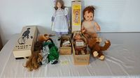 Wide shot showing nine vintage dolls and puppets including boxed and unboxed items, plush monkey, and dolls in various clothing.