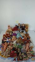 Full view of assorted vintage miniature dolls arranged on a surface. Various styles, costumes, materials visible.