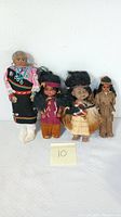 Four vintage Native American dolls displayed side by side on a white surface with a number 10 card.