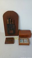 Wooden wall plaque with block letters, two wooden storage boxes, and wooden playing card case with cards inside.
