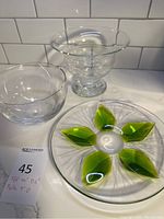 Overall lot of the three glassware items: Tiffany clear glass bowl, clear bowl, and signed green glass plate with leaf design.