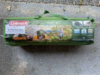 Photo of the green Coleman bag with tent specifications and branding visible, including dimensions 10 ft x 8 ft and capacity for 5 persons.