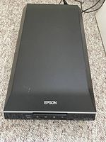 Top-down view of closed scanner showing lid and Epson logo