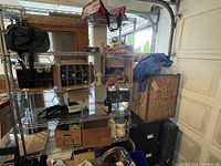 Wide view of metal shelving unit with assorted contents, including several cardboard boxes and miscellaneous items.
