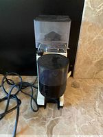 Front view showing entire grinder with hopper and grounds container