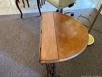 View of the folded dropleaf table top with visible wood grain and wear marks.