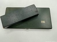 Closed green leather carrying case with K&E logo.