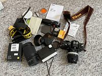 Overall view of camera body, lens, straps, filters, manuals, flash, exposure meter, film box and pouch