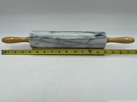 Rolling pin placed horizontally next to a measuring tape showing total length around 15 inches