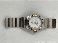Full view of watch face and integrated bracelet laid flat