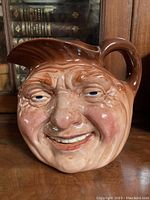 Front view of Royal Doulton Toby jug with detailed facial features and glossy glaze.