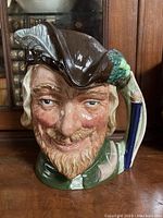 Front view showing the detailed facial features and hat with feather of the Robin Hood Toby mug