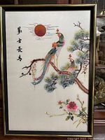Full view of framed Chinese embroidery art showing two birds on tree branches, sun, and Chinese characters