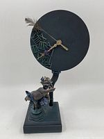 Full view of decorative clock showing round face on cherub figurine base