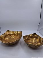 Photo showing both brass centrepiece bowls together, highlighting size difference and irregular shapes.